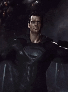 a close up of a man in a black superman suit