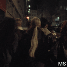 a group of people are walking down a dark street and the letters ms are on the bottom