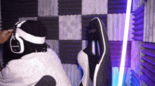 a person wearing headphones is sitting in a chair that says dxracer on it