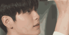 a close up of a person 's face with a white shirt