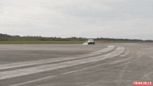 a white car is driving on a track with thinkjules written on the bottom right
