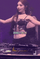 a woman is dancing in front of a pioneer dj mixer ..