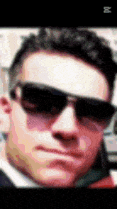 a blurry picture of a man wearing sunglasses with the letter m on the bottom