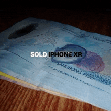 a stack of money with the words sold iphone xr written on it