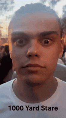 a close up of a man 's face with the words 1000 yard stare below