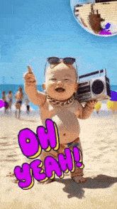 a baby is holding a boombox on the beach .