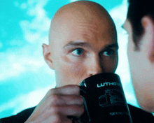 a man drinking from a black mug that says luthor on it