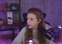 a woman sitting in front of a shure microphone with a surprised look on her face