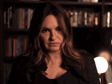 a woman is making a face in front of a bookshelf
