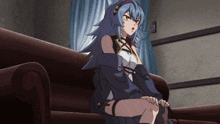 a girl with blue hair sits on a brown couch