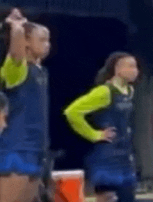a group of people are standing next to each other on a stage . one of the people is wearing a green shirt .