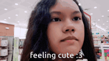 a girl in a store with the words feeling cute 3 on her face