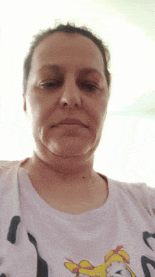 a woman wearing a white shirt with a picture of a duck on it