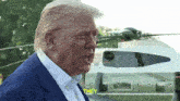 a man in a suit stands in front of a helicopter and says " they " in yellow letters