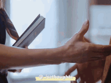 a close up of a person holding a book with the hashtag @isathoughts on the bottom