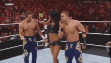 two men and a woman are dancing in a wrestling ring with the words i love wrestling gifs on the bottom