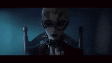 a woman in a mask is sitting in a chair in a dark room