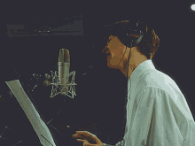 a man wearing headphones is singing into a sony microphone