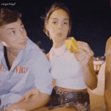 a girl eating an ice cream cone next to a boy whose shirt says vita
