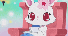 a white cat with a pink flower on its head is sitting in a pink chair holding a cup of tea .