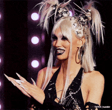 a woman with long white nails and a wig with spikes on her head
