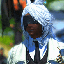 a man wearing a blindfold and a white jacket