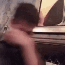 a blurry picture of a person standing in front of a refrigerator .