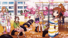 a group of anime girls are standing in a playground with cherry blossoms in the background .