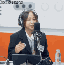 a woman wearing headphones is talking into a microphone .