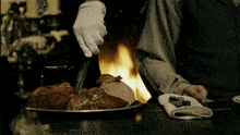 a person wearing white gloves is cutting meat with a knife