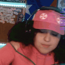 a girl wearing headphones and a pink hat with a candy cane on it