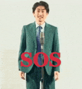 a man in a green suit and tie is dancing in front of a microphone with the word sos in red .