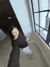 a woman in a black sweater is taking a selfie in front of a window