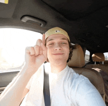 a young man wearing a yellow hat with the letter a on it