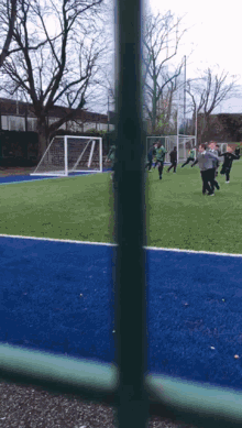 a group of people are playing soccer on a blue field