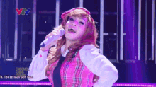 a woman singing into a microphone with endemol shine group on the bottom right