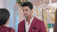 a man in a red suit stands next to a woman in a red dress