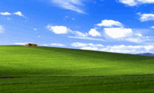 a house sits on the top of a grassy hill