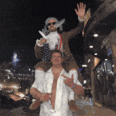a man in an american flag costume is carrying another man
