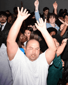 a man in a white shirt is dancing in a crowd