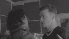 a black and white photo of a man and woman dancing .