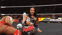 two women in a wrestling ring with a sign that says pal
