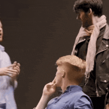 a man in a blue shirt is talking to another man