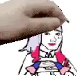 a close up of a person 's hand holding a cartoon character 's head .