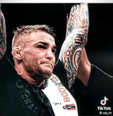 a man with a tattoo on his arm is wearing a shirt that says ' bodyarmor ' on it