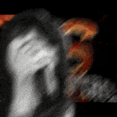a blurry picture of a person 's face with a red and orange background