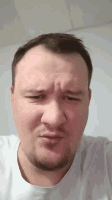 a man with a beard is making a funny face