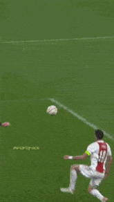 a soccer player in a red and white jersey kicks the ball