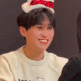 a young man wearing a santa hat is smiling and laughing .