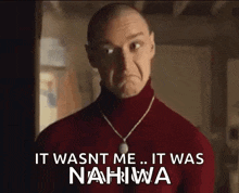 a bald man wearing a red sweater and a necklace is making a sad face .